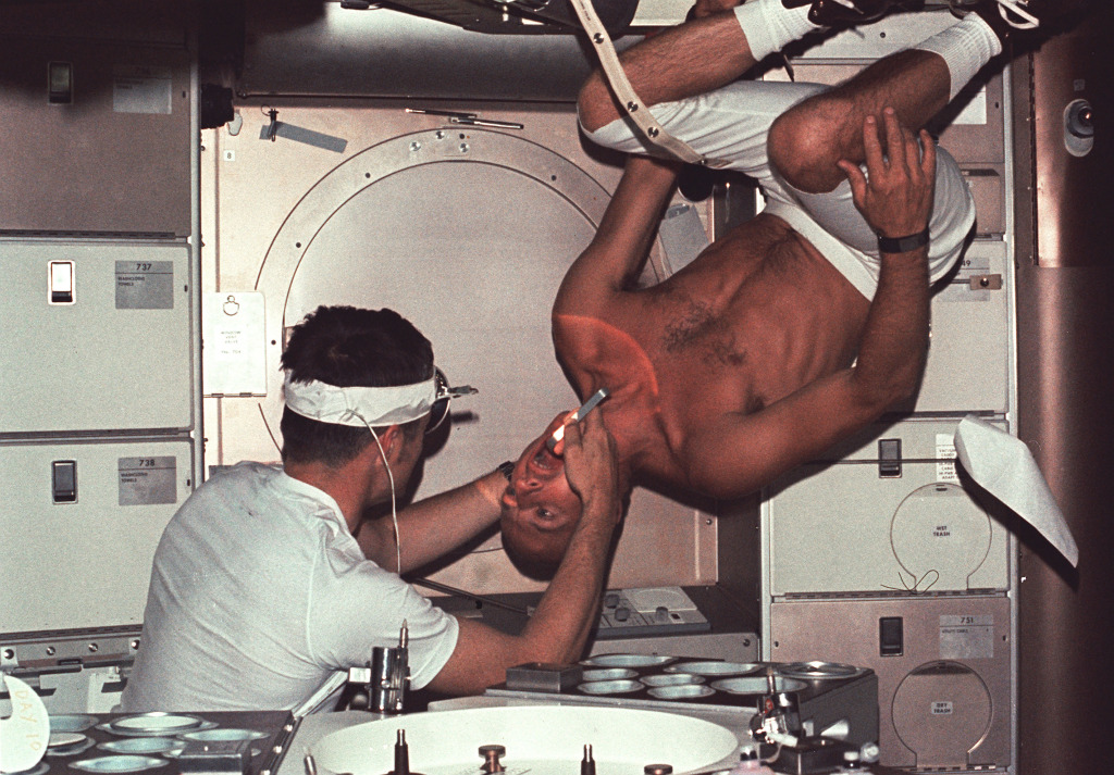Skylab 1 commander Pete Conrad undergoes a dental examination by medical officer Joseph Kerwin. – Credits: NASA.
